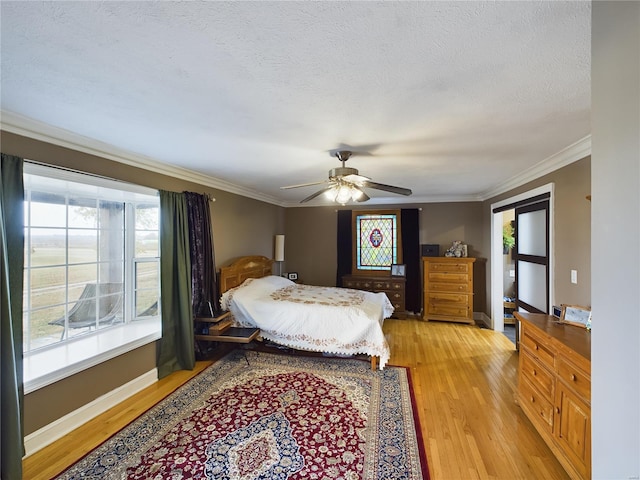 bedroom featuring ceiling fan, crown molding, light hardwood / wood-style floors, and a textured ceiling