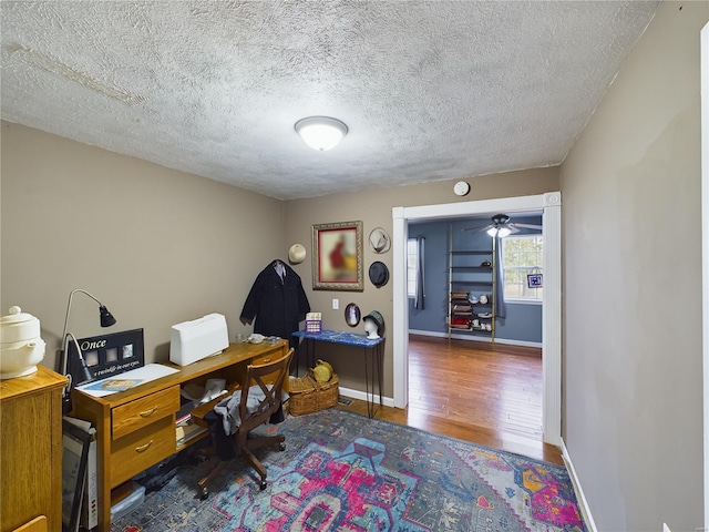 office with ceiling fan, dark hardwood / wood-style flooring, and a textured ceiling