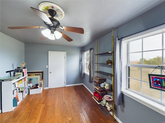 miscellaneous room with hardwood / wood-style floors, ceiling fan, and a textured ceiling