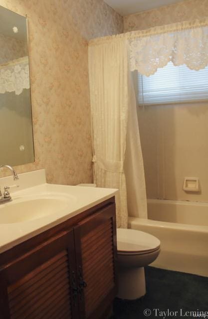 full bathroom with shower / tub combo with curtain, vanity, and toilet