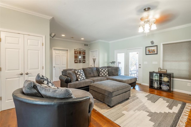 living room featuring hardwood / wood-style floors, ceiling fan, and crown molding