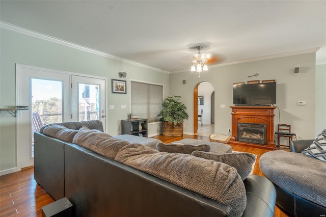 living room with hardwood / wood-style floors, ceiling fan, and crown molding