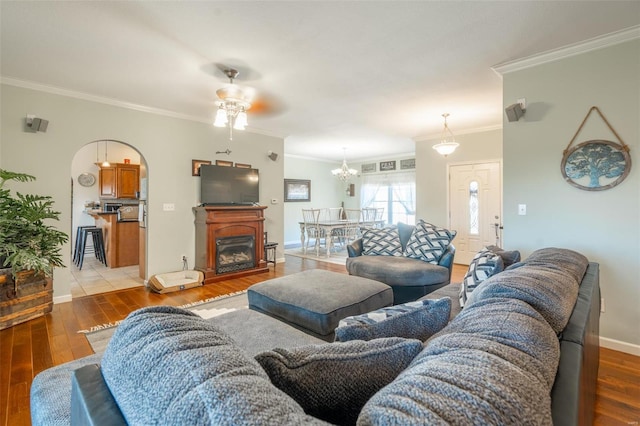 living room featuring light hardwood / wood-style floors, ceiling fan, and crown molding