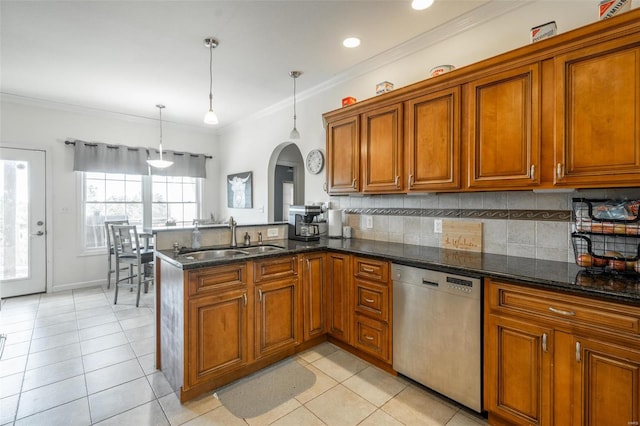 kitchen featuring dark stone counters, kitchen peninsula, sink, stainless steel dishwasher, and decorative light fixtures