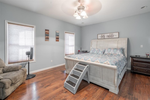 bedroom featuring multiple windows, dark wood-type flooring, and ceiling fan