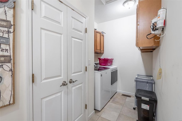 clothes washing area featuring cabinets, independent washer and dryer, and light tile patterned floors