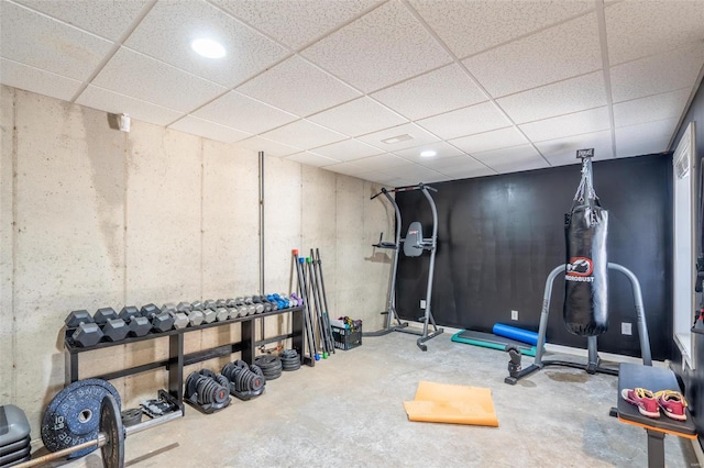 workout room with a drop ceiling and concrete floors