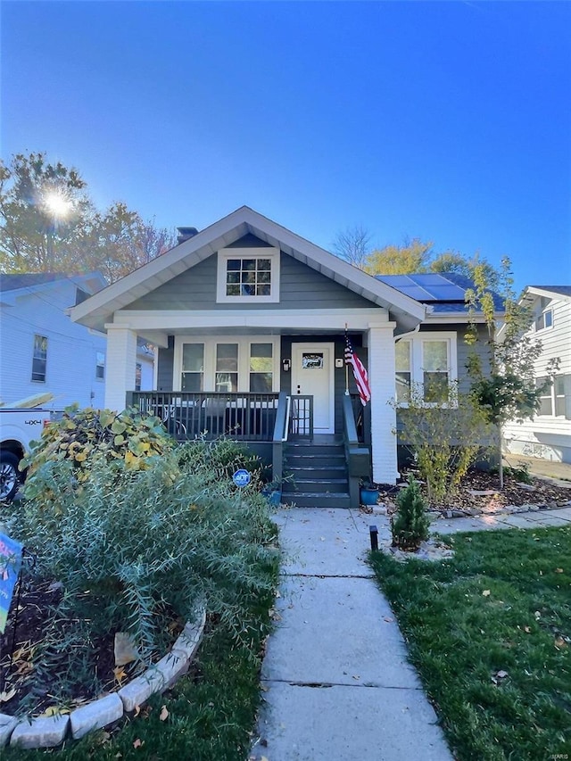 view of front of home with solar panels and a porch