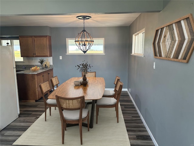 dining room featuring dark wood-type flooring and a chandelier