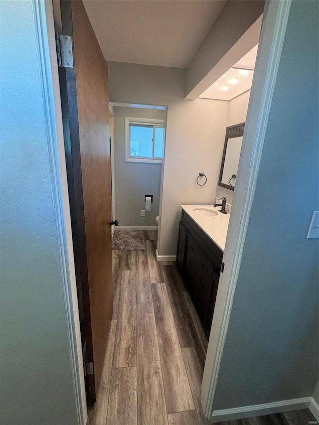 bathroom with hardwood / wood-style floors, vanity, and toilet