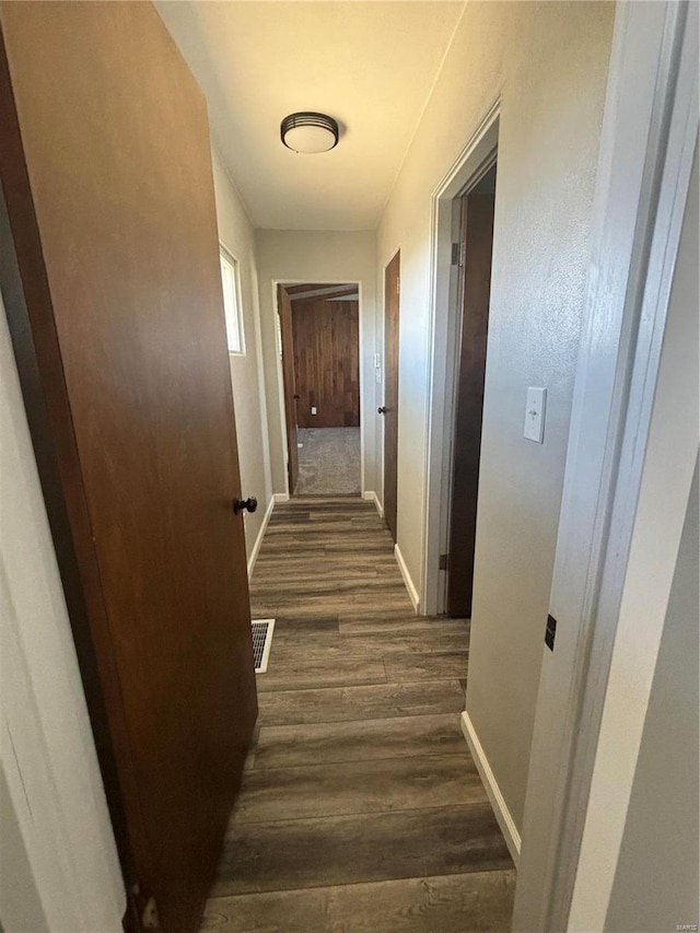 corridor with dark hardwood / wood-style flooring