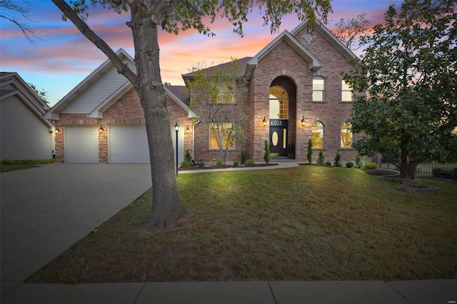 view of front of property with a garage and a lawn