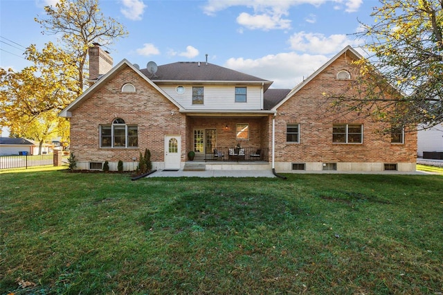 back of property with a yard and a patio