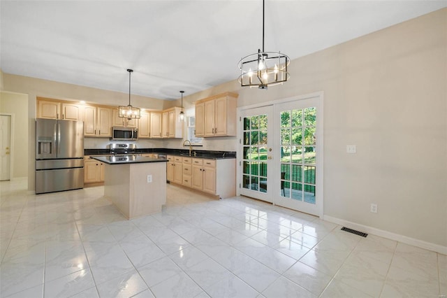 kitchen with a center island, an inviting chandelier, decorative light fixtures, light brown cabinetry, and appliances with stainless steel finishes