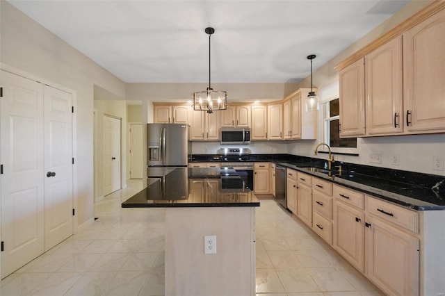 kitchen featuring appliances with stainless steel finishes, light brown cabinets, a kitchen island, and hanging light fixtures