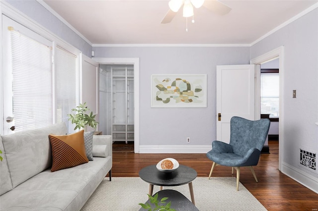 living room featuring wood-type flooring, ceiling fan, and crown molding