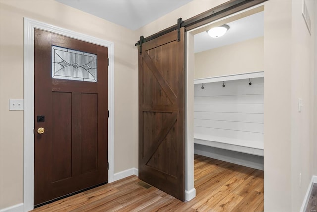 foyer with a barn door and light hardwood / wood-style floors