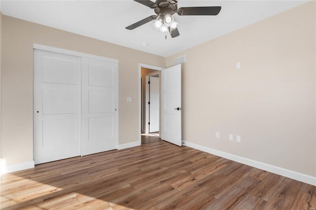 unfurnished bedroom with a closet, ceiling fan, and hardwood / wood-style flooring