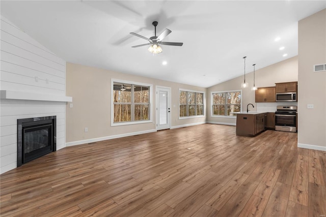 unfurnished living room with ceiling fan, dark hardwood / wood-style flooring, vaulted ceiling, and sink