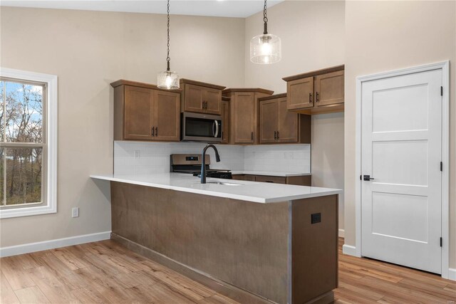 kitchen featuring decorative backsplash, appliances with stainless steel finishes, and decorative light fixtures