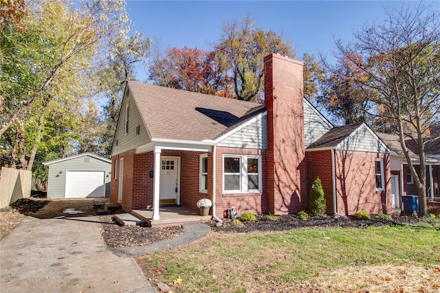 view of front of home with a garage, an outdoor structure, and a front lawn