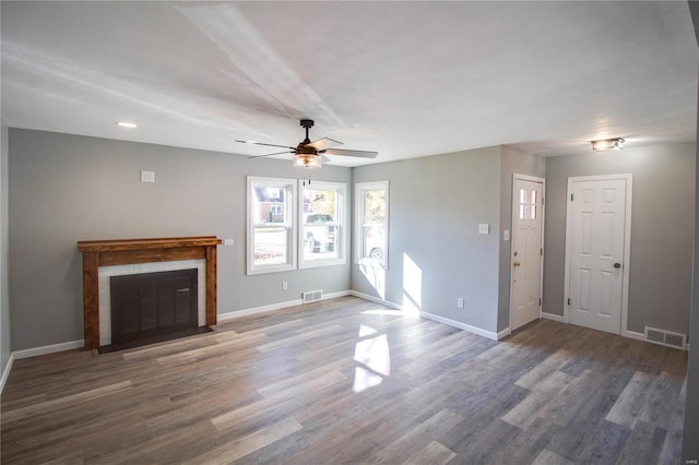 unfurnished living room featuring ceiling fan and dark hardwood / wood-style floors