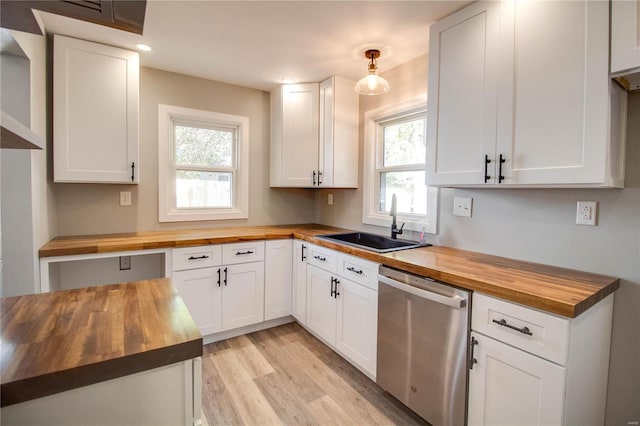 kitchen featuring butcher block counters, white cabinetry, plenty of natural light, and dishwasher