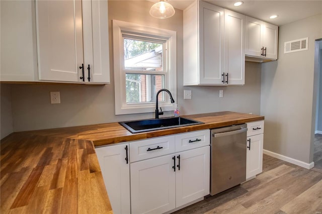 kitchen featuring dishwasher, butcher block countertops, sink, and white cabinets