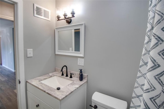 bathroom featuring hardwood / wood-style floors, vanity, and toilet