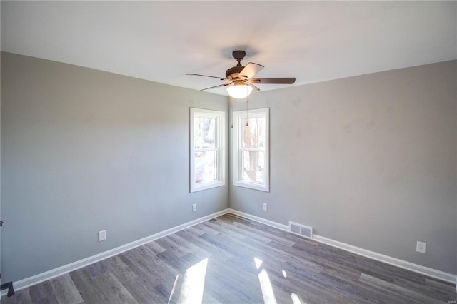 empty room featuring ceiling fan and dark hardwood / wood-style flooring