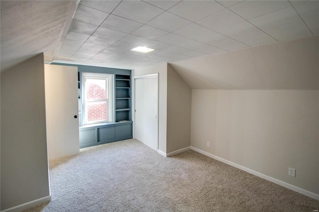 additional living space with vaulted ceiling and light colored carpet