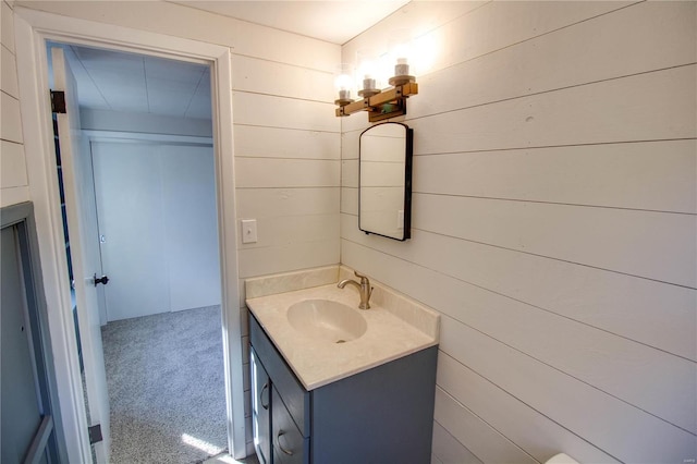 bathroom featuring vanity and wooden walls