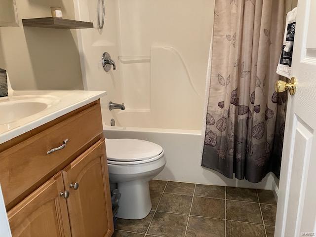 full bathroom with toilet, shower / tub combo with curtain, vanity, and tile patterned floors