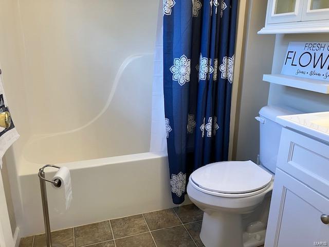 full bathroom featuring vanity, tile patterned floors, shower / bathtub combination with curtain, and toilet