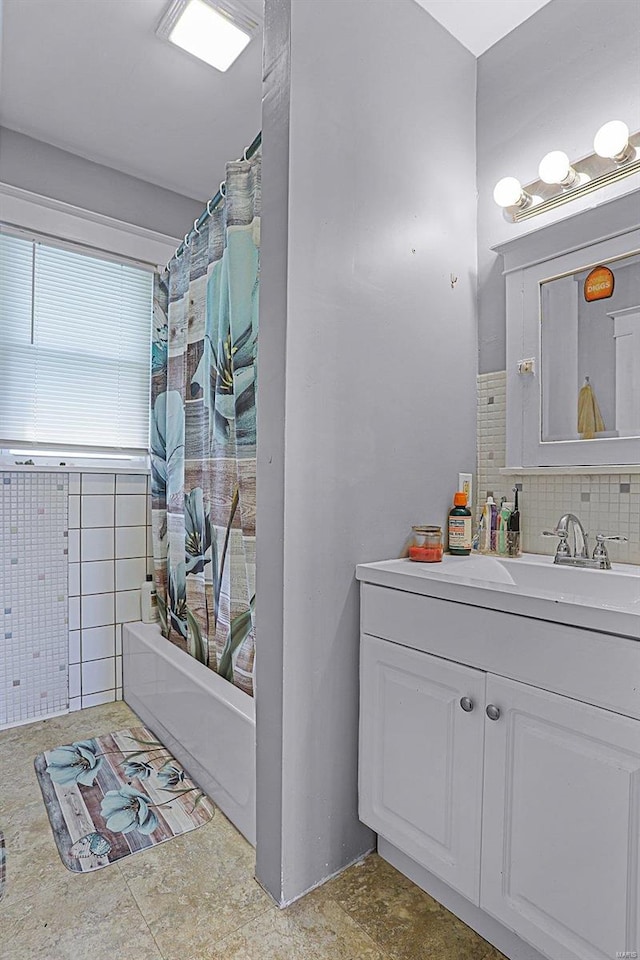 bathroom featuring tile walls, vanity, and shower / bathtub combination with curtain