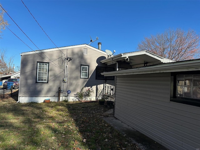 view of side of home with a yard