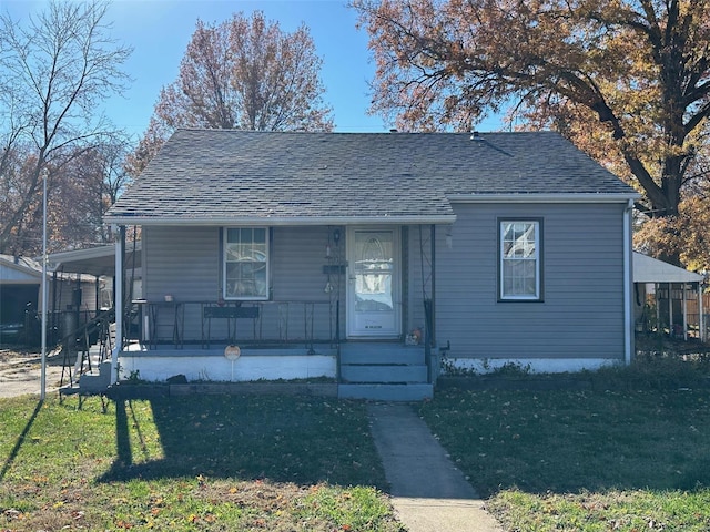 bungalow featuring a front lawn, a porch, and a carport