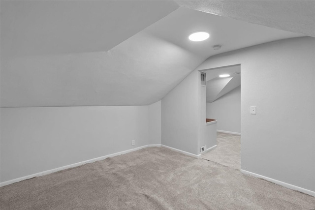 additional living space with light colored carpet and lofted ceiling