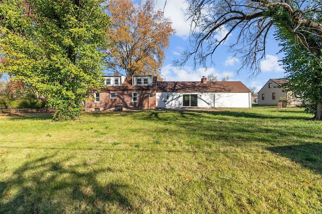 rear view of property with a yard