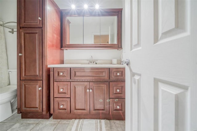 bathroom featuring tile patterned flooring, vanity, and toilet