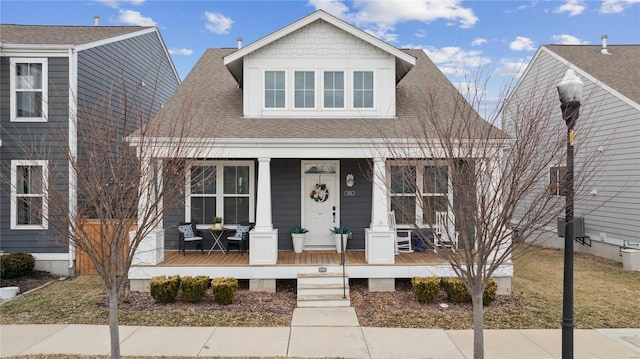 bungalow-style home featuring roof with shingles and a porch