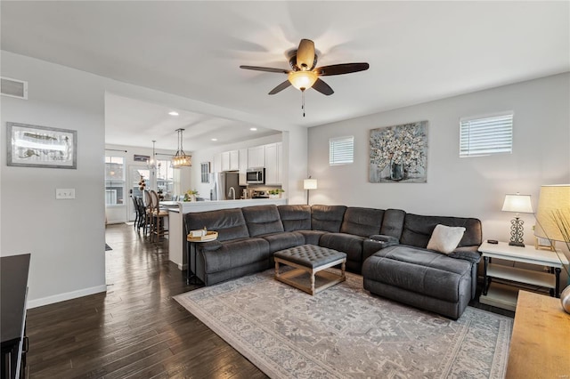 living area featuring wood finished floors, visible vents, baseboards, recessed lighting, and ceiling fan with notable chandelier