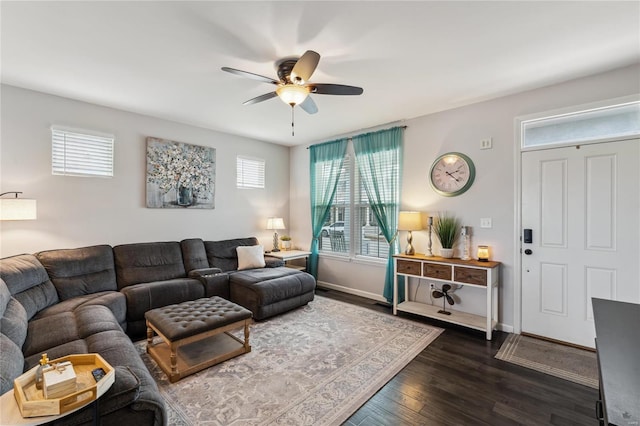 living area featuring baseboards, dark wood-type flooring, and ceiling fan