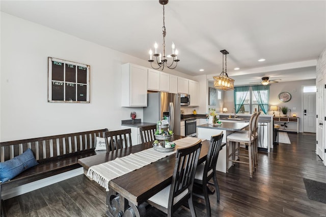 dining space featuring dark wood-style floors, recessed lighting, and ceiling fan with notable chandelier