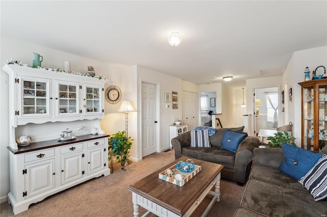 living area featuring baseboards and light colored carpet