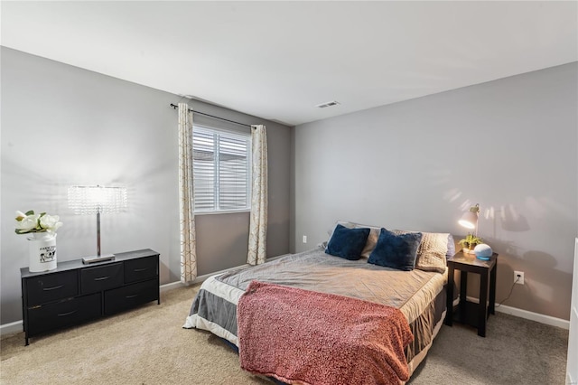 bedroom featuring visible vents, light colored carpet, and baseboards