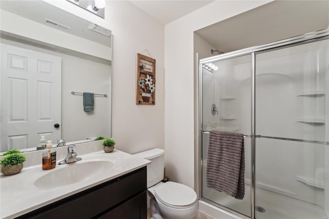 bathroom with vanity, toilet, visible vents, and a stall shower