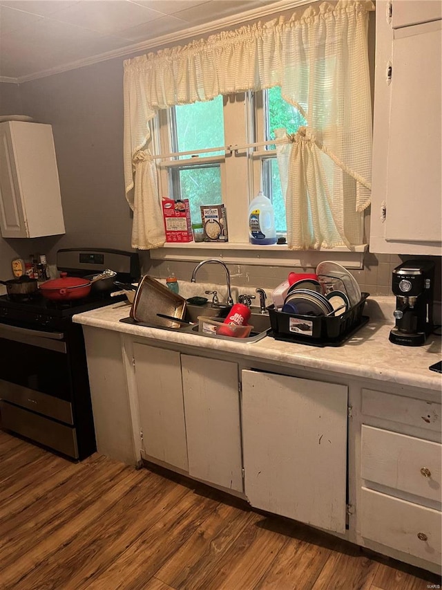 kitchen featuring white cabinetry, sink, hardwood / wood-style floors, stainless steel electric range, and crown molding