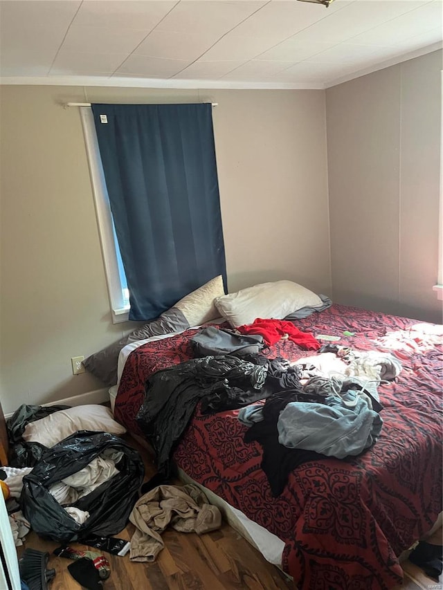 bedroom featuring hardwood / wood-style flooring and ornamental molding