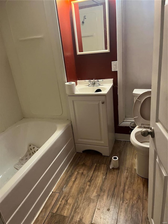 bathroom with wood-type flooring, toilet, and vanity